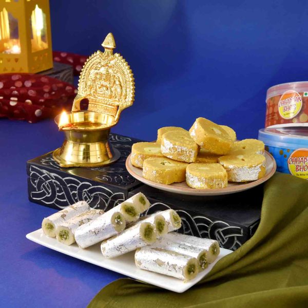This hamper includes Brass Kamakshi Diya, Chappan Bhog Pista Rol, & Batisha Slice
