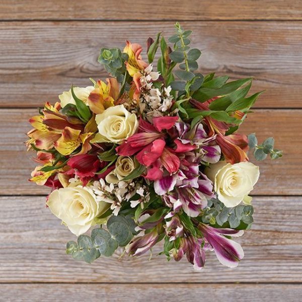 This floral arrangement is made with white roses and mixed peruvian lilies.
