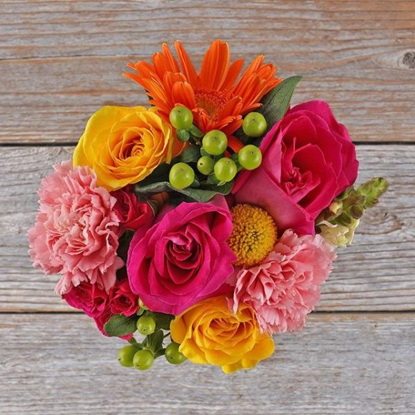 Sugar Rush Bouquet featuring hot pink and yellow roses with pink carnations.