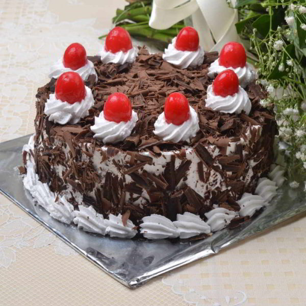 Eggless Black forest Cake with some red cherries on it